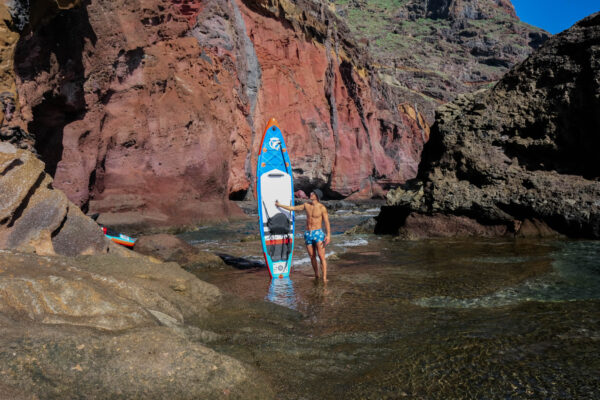 Explorer with stand-up paddleboard in a secluded coastal spot in Tenerife South – full-day SUP rental