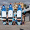 3 Friends holding their paddleboards before entering the water to explore in Alcalá Tenerife